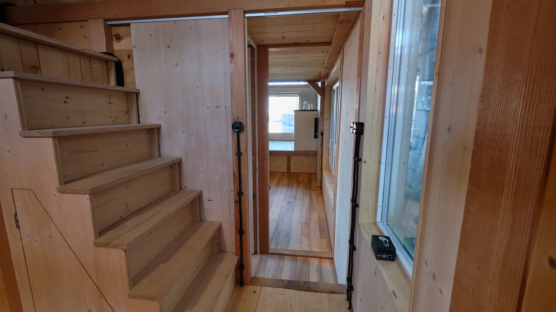 Die Treppe führt hinauf zum Schlafbereich und bietet integrierter Stauraum. Eine Schiebetür ermöglicht eine Unterteilung der Räume. Hochwertige Bakelit-Lichtschalter ermöglichen die Bedienung des Lichtes.