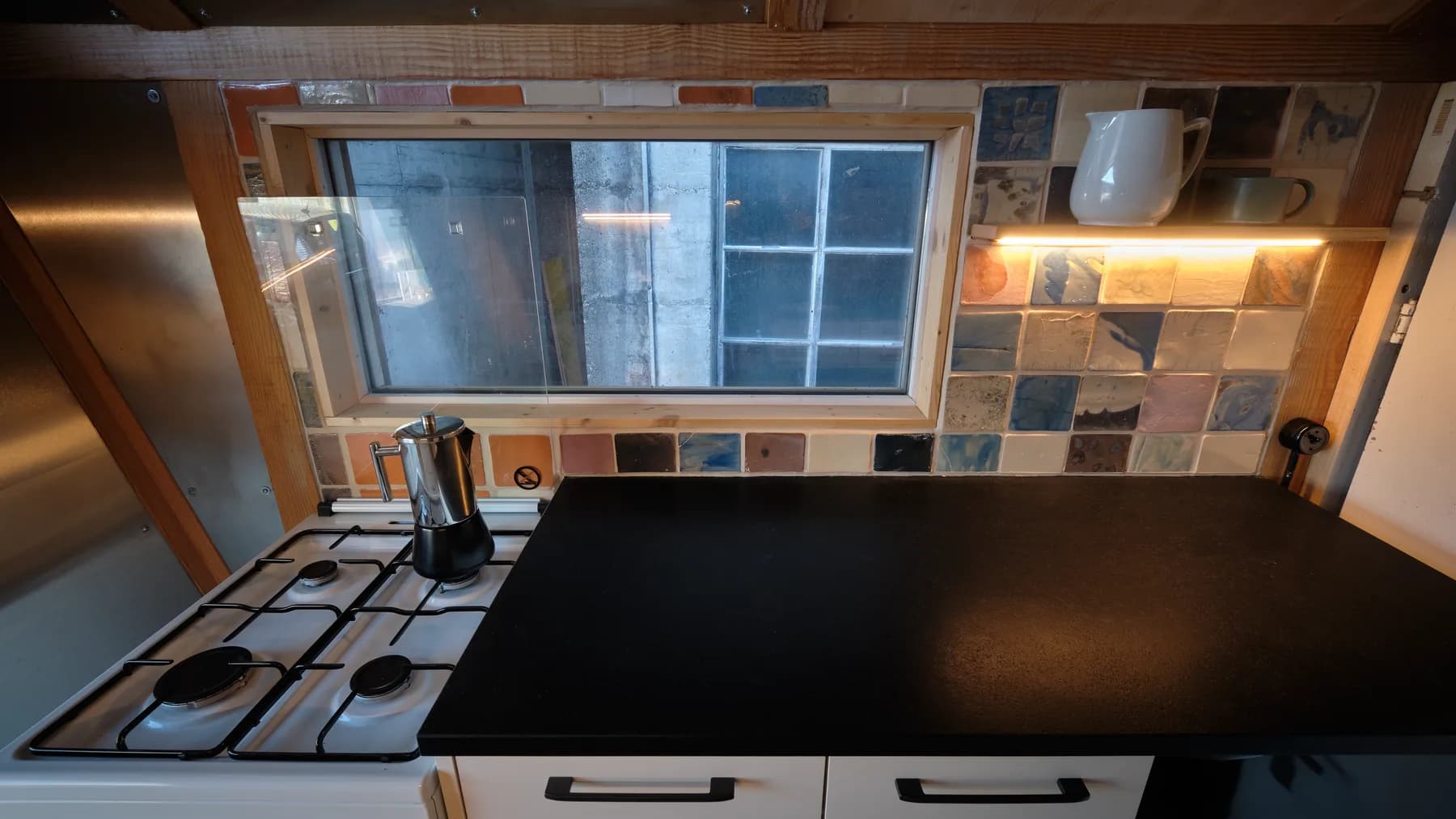 Kochfeld mit Backofen und Fliesenwand