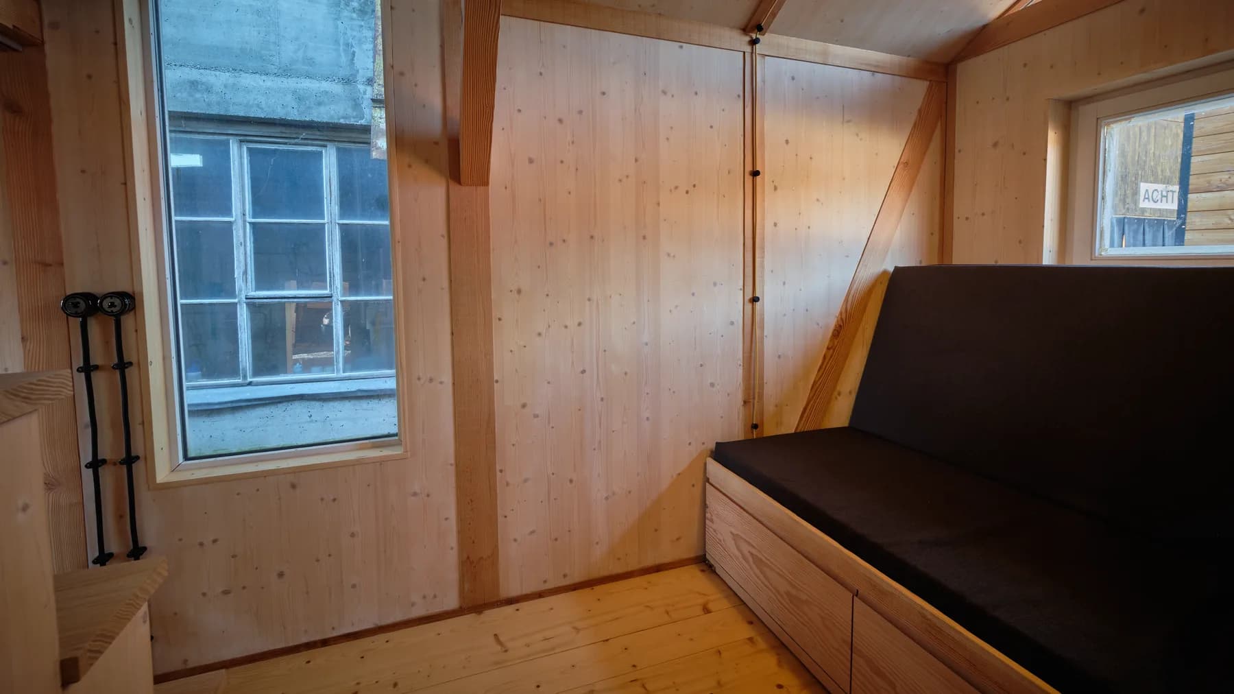 Sitzbank an der Holzwand mit Fenster