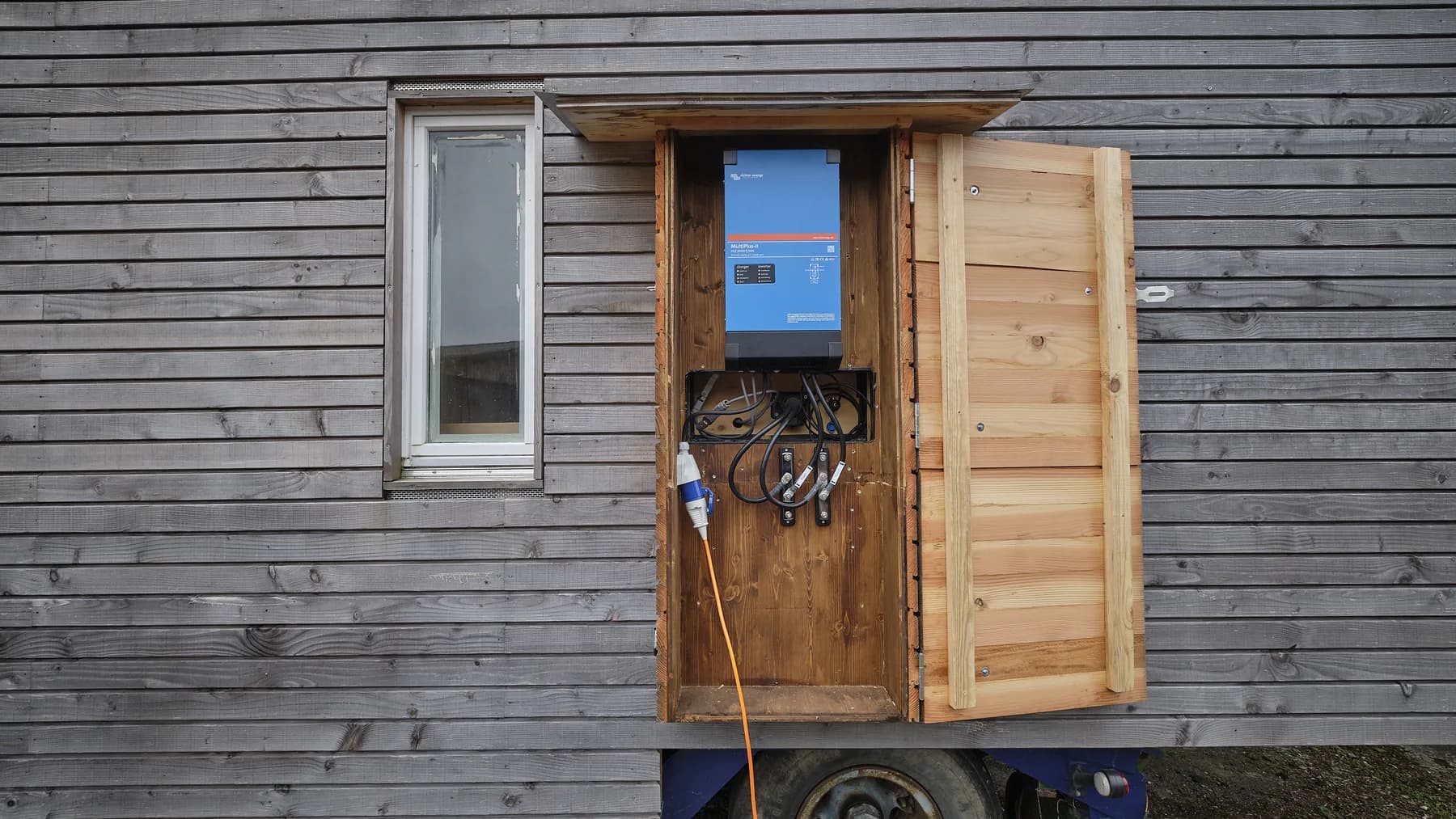 Zwei Batterien ermöglichen das Speichern von Energie. Ein Victron-Multiplus-Gerät ist an der Aussenwand installiert, welches das Laden der Batterien und die Umwandlung von 230V nach 12V (Licht, Kühlschrank, Komposttoilette) ermöglicht. Ein direkter Anschluss zu 230V ist ebenfalls vorhanden.